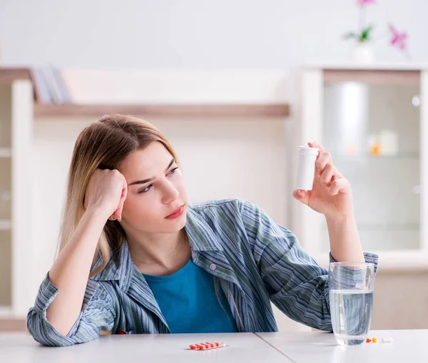 Žena si bere pilulky, aby zvládla bolest — Stock fotografie