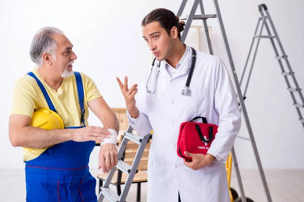 応急処置の概念の若い男性医師と古い請負業者 — ストック写真
