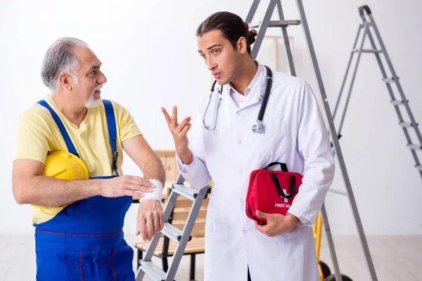 İlk yardım konseptinde genç erkek doktor ve yaşlı müteahhit.