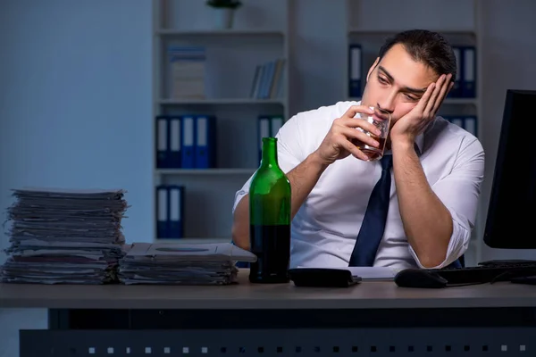 Podnikatel závislý na alkoholu pracuje dlouho do noci v kanceláři — Stock fotografie