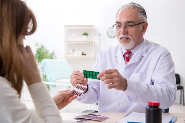 Jovem mulher visitando médico experiente — Fotografia de Stock