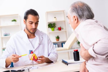 Yaşlı adam genç doktor kardiyoloğu ziyaret ediyor.