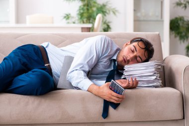 Genç erkek işadamı evde çalışıyor.