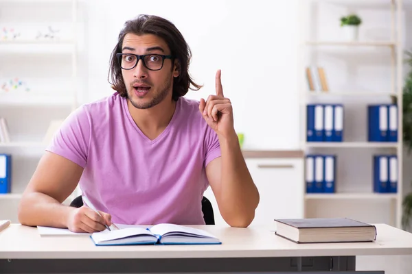 Giovane studente maschio che si prepara per gli esami in classe — Foto Stock