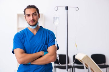 Klinikte çalışan genç erkek doktor.