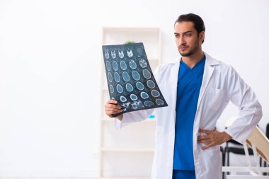 Klinikte çalışan genç erkek doktor.