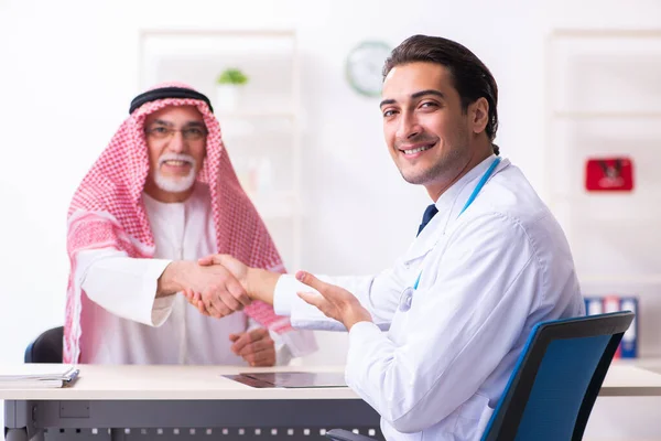 Old male arab visiting young male doctor — Stock Fotó