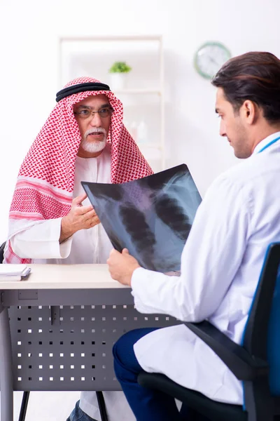 Viejo árabe masculino visitando joven médico masculino —  Fotos de Stock