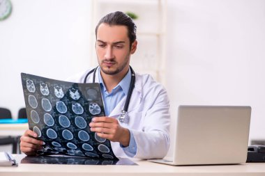 Klinikte çalışan yakışıklı genç erkek doktor.