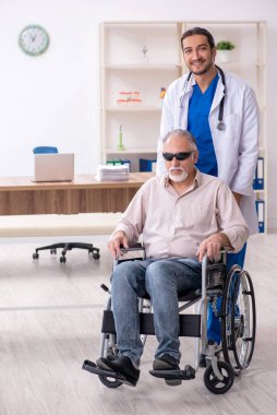 Yaşlı kör adam genç erkek doktoru ziyaret ediyor.