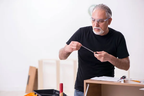 Yaşlı erkek marangoz içeride çalışıyor. — Stok fotoğraf