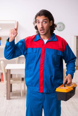 Genç erkek marangoz içeride çalışıyor.