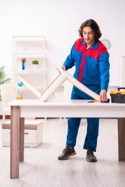 Genç erkek marangoz içeride çalışıyor.