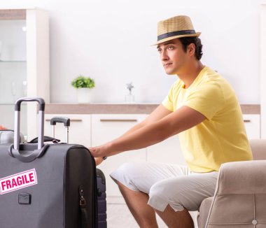 Kırılgan bavullarla tatile çıkan adam.