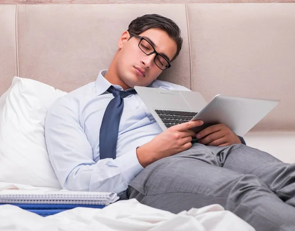 Бізнесмен працює в ліжку вдома — стокове фото