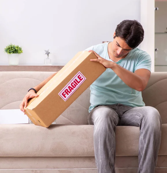 Mann öffnet fragiles Paket, das im Internet bestellt wurde — Stockfoto