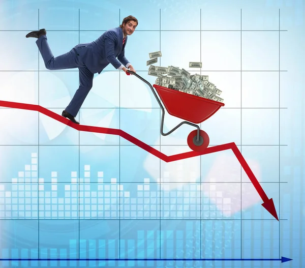 Üzletember nyomja pénz talicska lefelé a diagramon — Stock Fotó