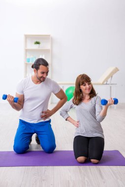 Kişisel koçla spor egzersizleri yapan genç bir kadın.