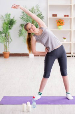 Spor salonunda egzersiz yapan genç bir kadın.