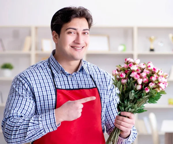 Asistente de floristería ofreciendo un ramo de flores — Foto de Stock