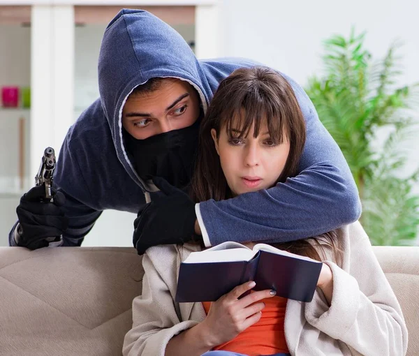 Armed man assaulting young woman at home — Stock Photo, Image