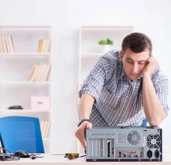 Young technician repairing computer in workshop — Stock Photo, Image