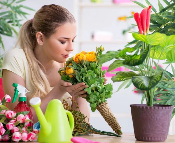 Young woman watering plants in her garden — Stock Photo, Image