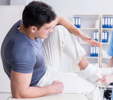 Hastanede yaralanma kontrolü sırasında doktor ve hasta.