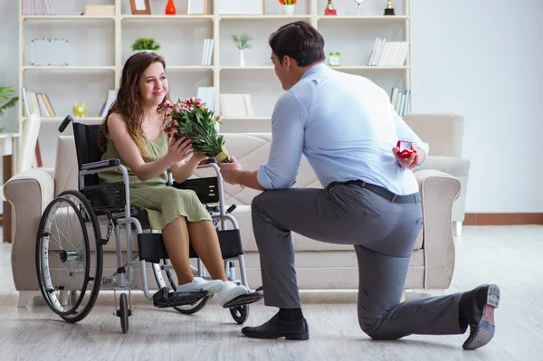 Man som friar till handikappad kvinna i rullstol — Stockfoto
