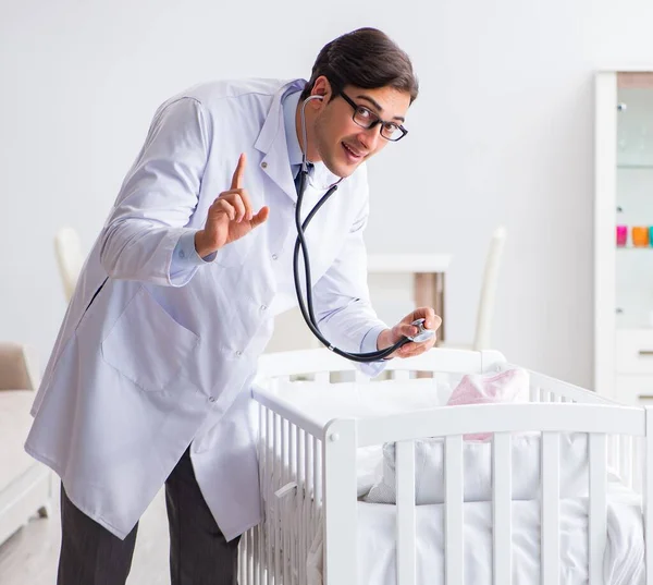Hombre pediatra masculino cerca de cama de bebé preparándose para examinar —  Fotos de Stock