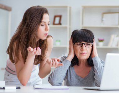 Kızı anneme bilgisayarın nasıl kullanılacağını anlatıyor.