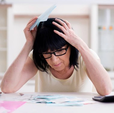 Faturalarını ödemeye çalışan olgun bir kadın.