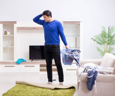 Genç adam çamaşırhane için kirli çamaşır topluyor.