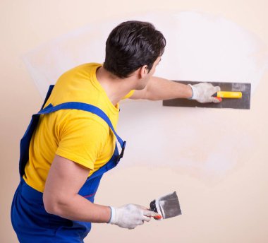 Duvara alçı yapıştıran genç müteahhit.