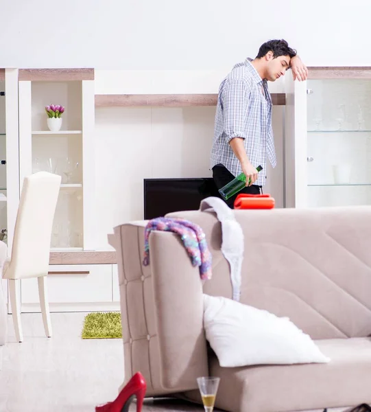 Man with mess at home after house party