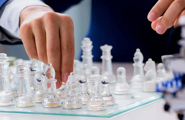 Young businessman playing glass chess in office — Stock Photo, Image