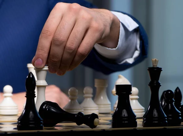 Uomo d'affari che gioca a scacchi nel concetto di strategia — Foto Stock