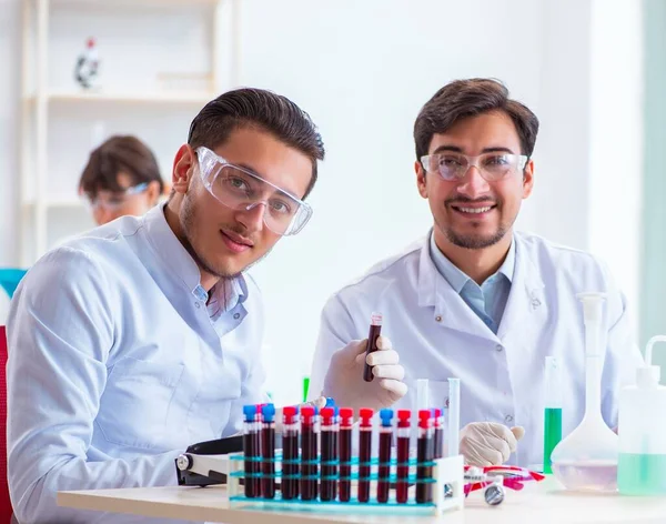 Equipe de químicos que trabalham no laboratório — Fotografia de Stock