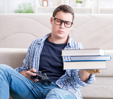 Çalışmayı ve oyun oynamayı dengelemeye çalışan genç öğrenci