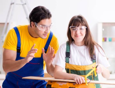 Ahşap atölyesinde kadın marangozluk ipuçlarını açıklayan adam