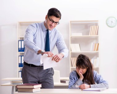 Erkek öğretim görevlisi bayan öğrenciye ders veriyor.