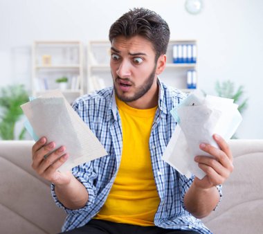 Ödeme yapması gereken faturalara kızgın bir adam.