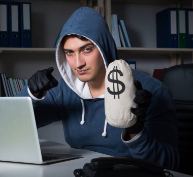 Genç hacker geceleri bilgisayarı hackliyor.