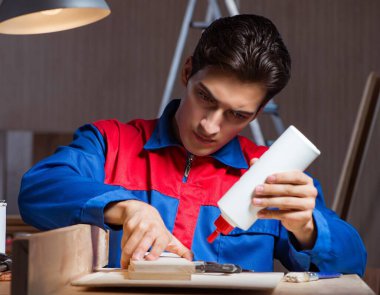Genç adam ahşap parçaları DIY konseptinde yapıştırıyor.