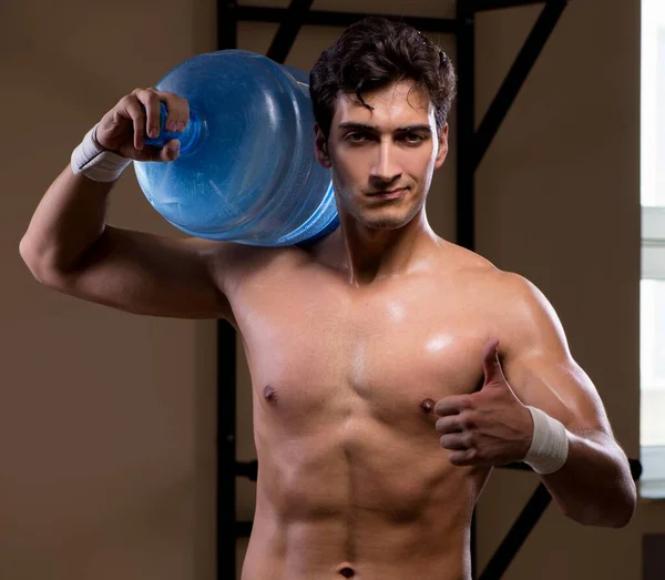 Uomo strappato muscolare con grande bottiglia d'acqua — Foto Stock
