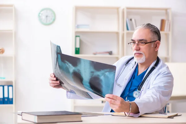 Oude mannelijke arts werkzaam in de kliniek — Stockfoto