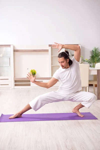 Young man doing physical exercises at home