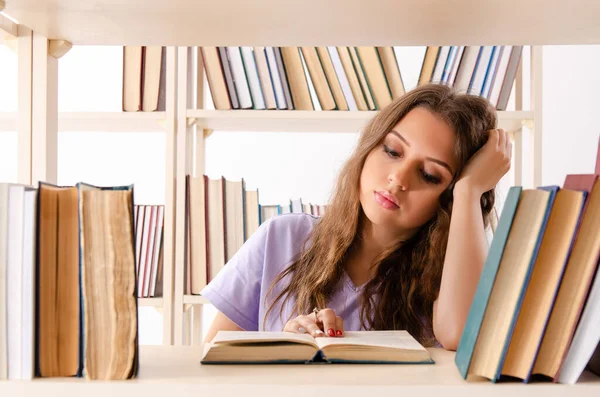 Jovem estudante se preparando para exames na biblioteca — Fotografia de Stock