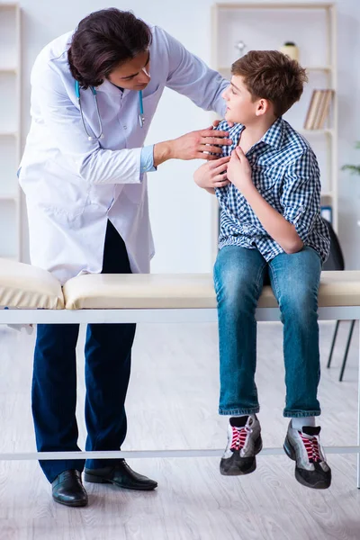 Jovem médico examinando estudante para check-up regular — Fotografia de Stock