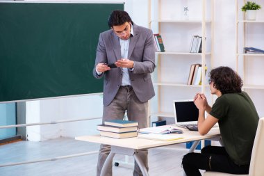 Genç öğretmen ve öğrenci sınıfta.